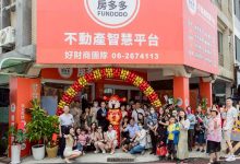 團隊成員在房多多不動產智慧平台店面前合影慶祝，象徵房地產課程與專業服務的實踐